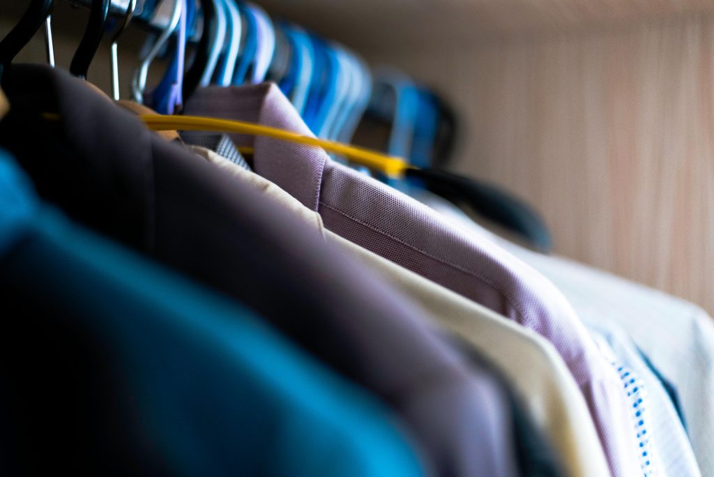 pexels photo 965632 965632 Close-up of various shirts hanging on colorful hangers inside a wardrobe.